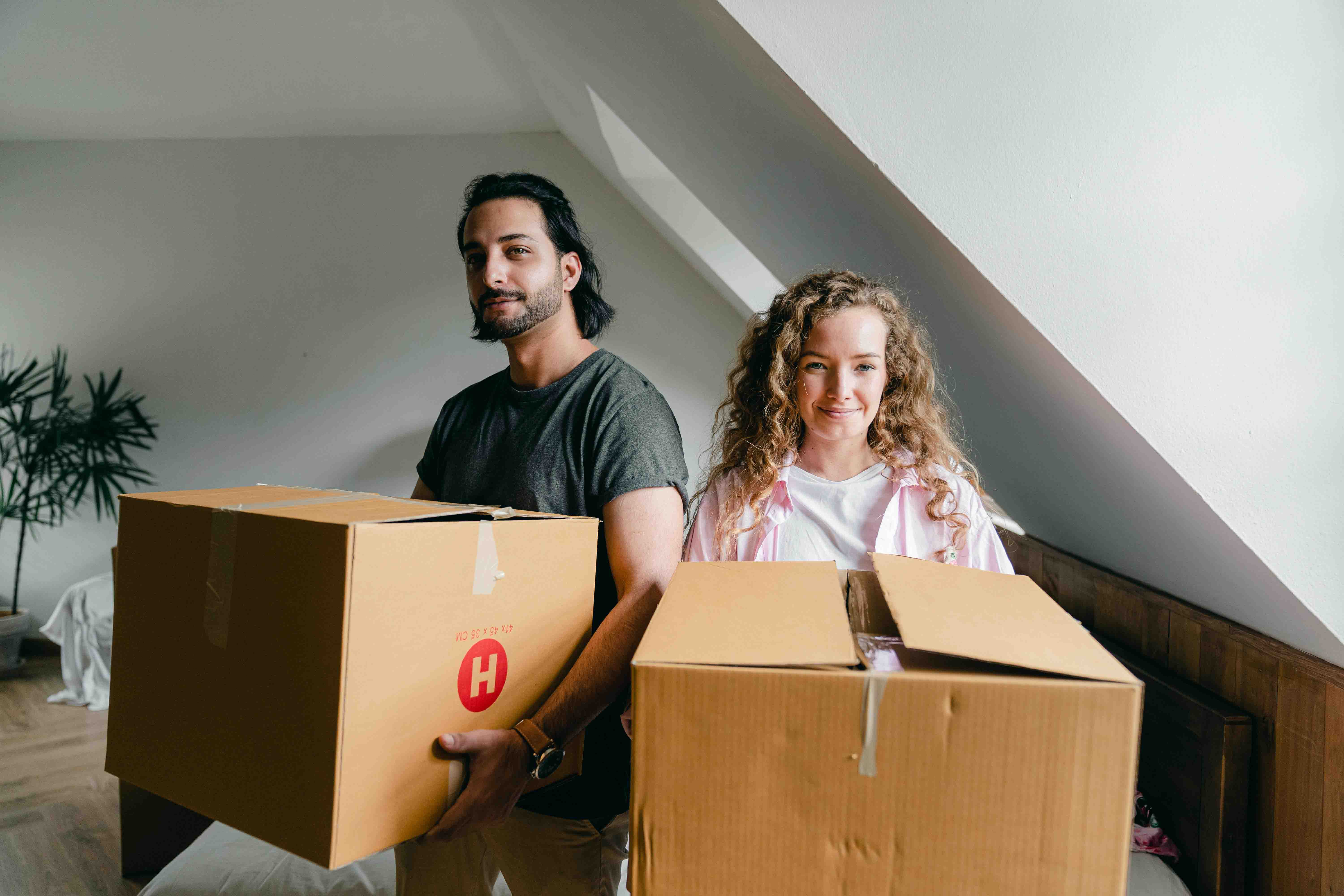 Man and woman holding moving boxes